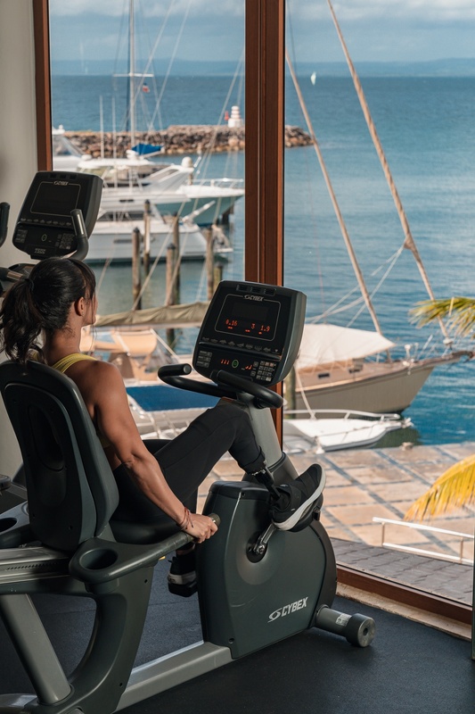 a woman is riding a cybex bike in a gym