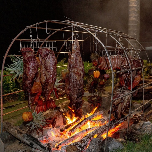 a bunch of meat is being cooked over a fire