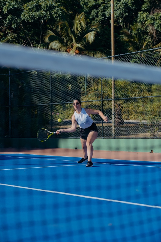 a woman is playing tennis on a blue court