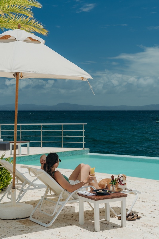 a woman laying on a beach chair with a drink in her hand