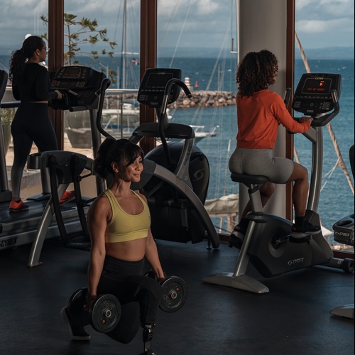 a woman squatting with a dumbbell in a gym