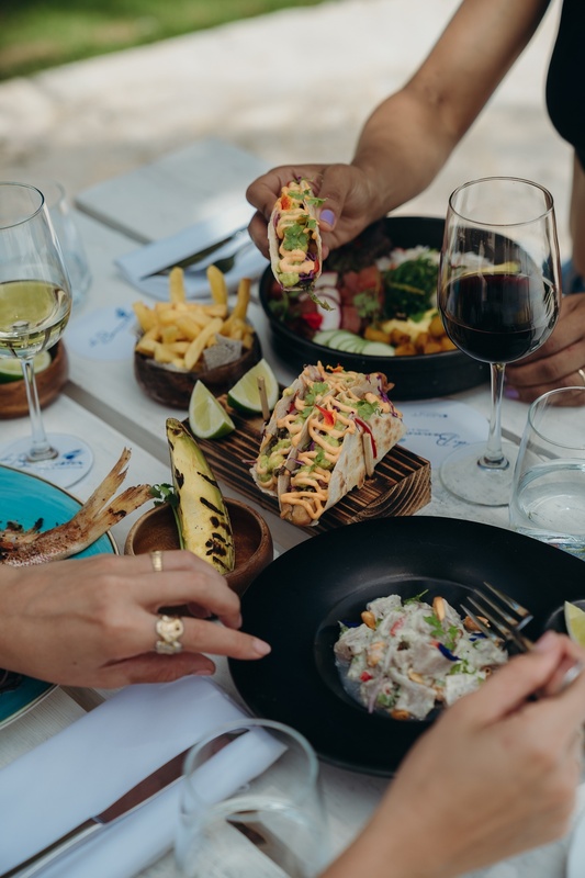 a woman is holding a taco over a plate of food
