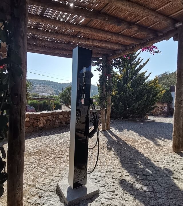 um farol vermelho e branco ao lado de um corpo de água