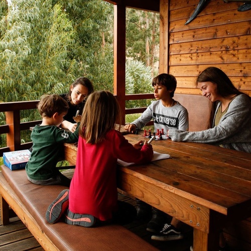 un grupo de niños juegan un juego de mesa en una mesa de madera