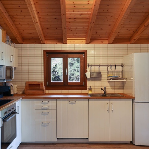 a kitchen with white cabinets and a bosch refrigerator