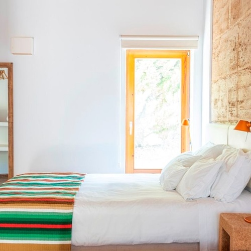 una habitación con una cama y un espejo en la pared