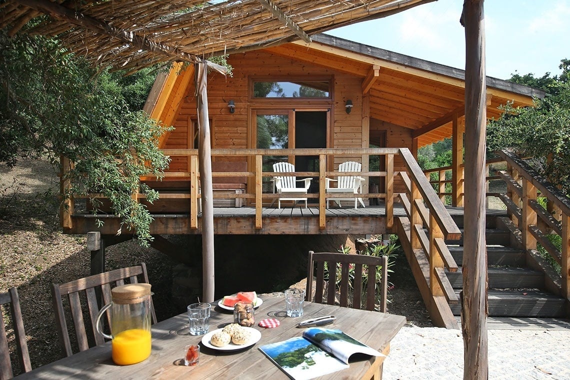 um homem está parado na varanda de uma cabana de madeira .