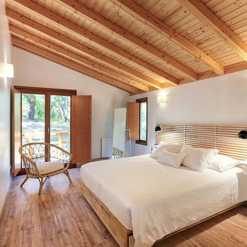 a bedroom with a wooden ceiling and a bed