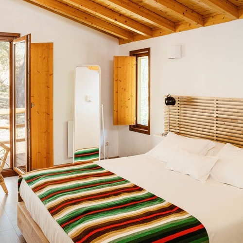 una habitación con una cama y una silla y un espejo