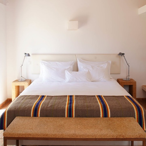 una habitación con una cama y dos mesitas de noche