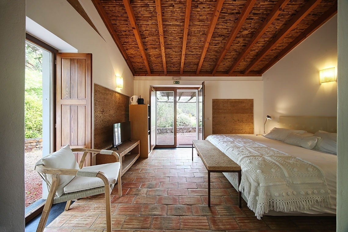 uma mesa de madeira e cadeiras ao lado de uma parede de tijolos