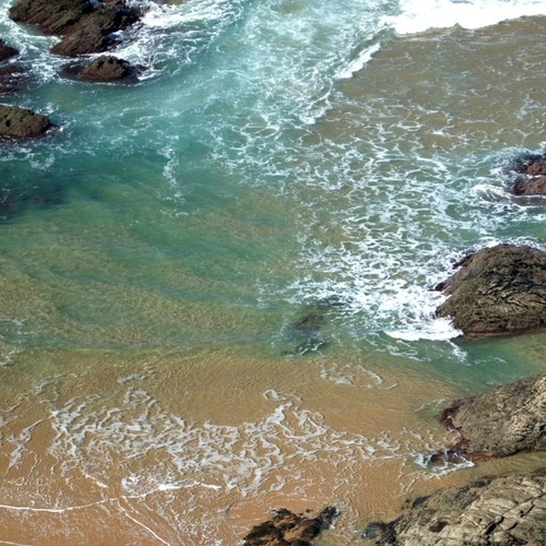 una vista aérea de una playa con rocas y olas