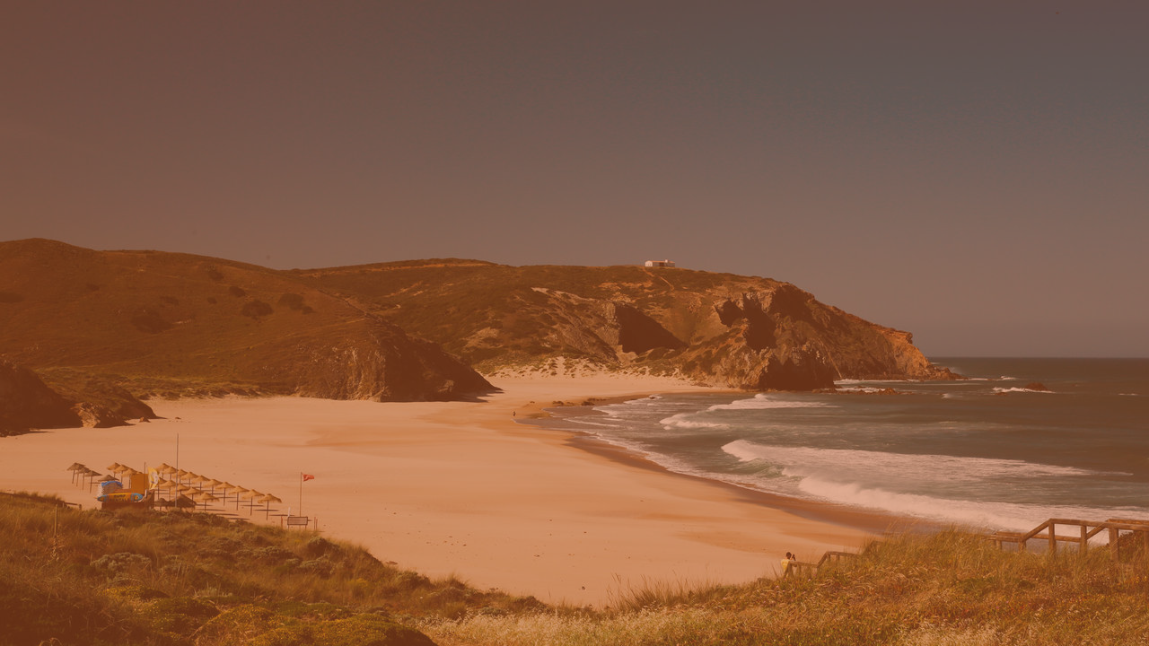 uma praia com um farol ao fundo=s1900