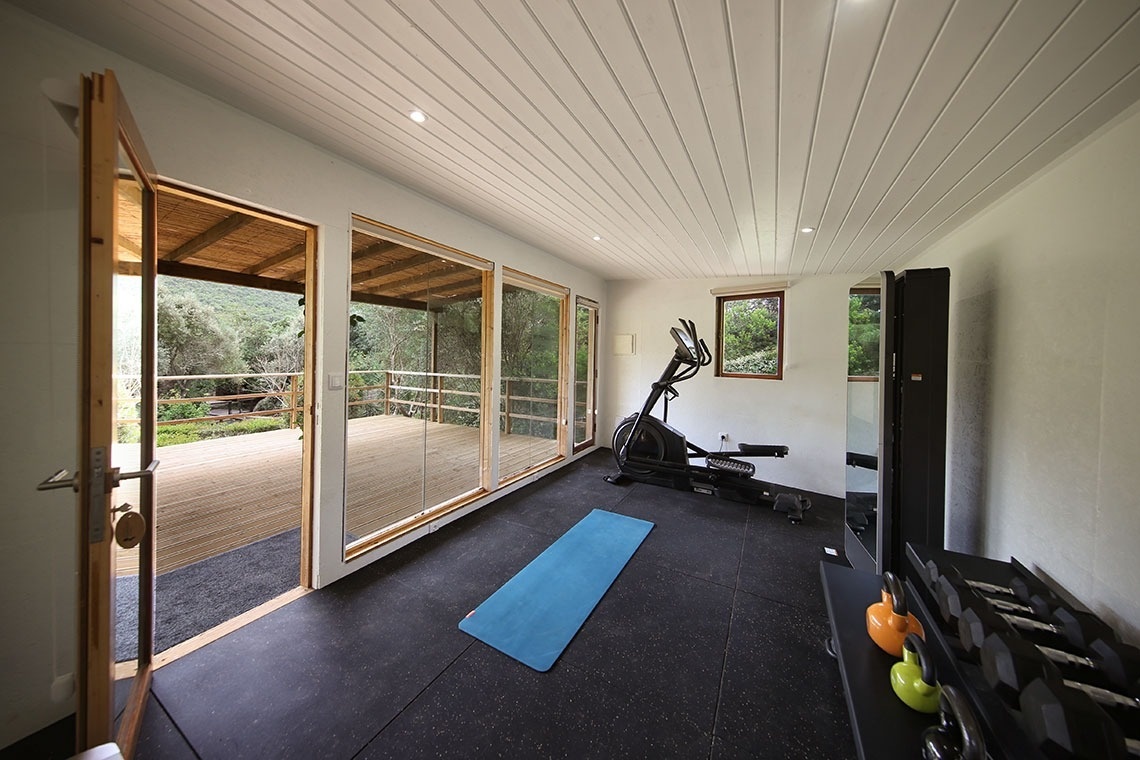 um ginásio com uma esteira de yoga e uma bicicleta elíptica