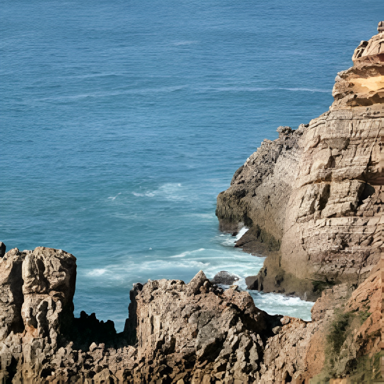a rocky shoreline with waves crashing against the rocks