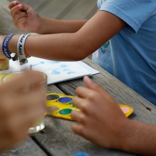 un niño con una pulsera que dice mar azul está pintando