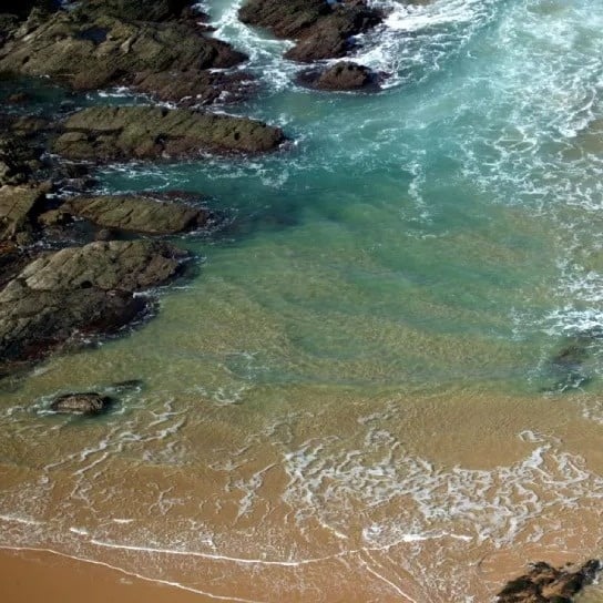 a rocky shoreline with waves crashing against the rocks