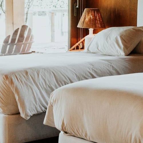 una habitación con dos camas y una lámpara