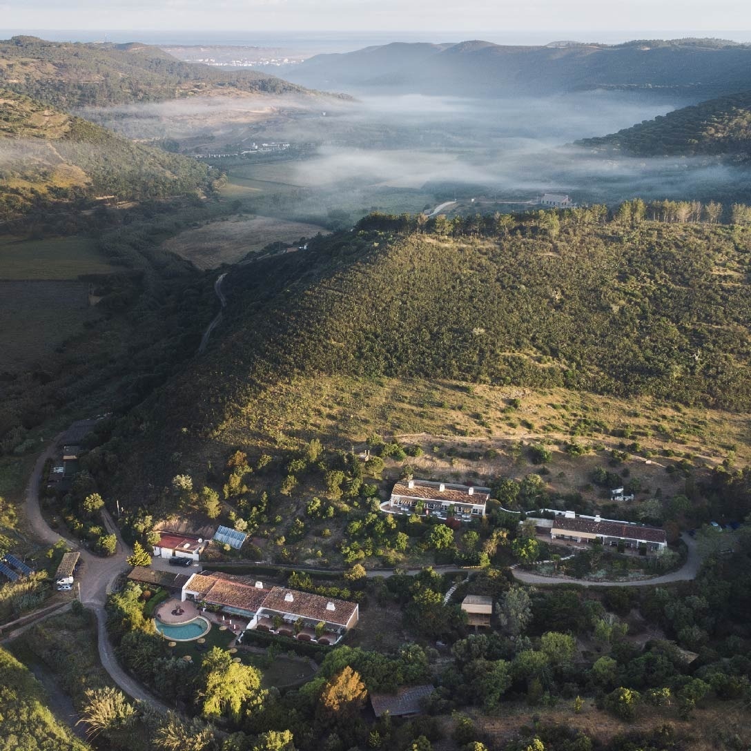 uma praia de areia com ondas e rochas