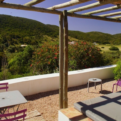 una mesa y sillas moradas en un patio con una vista de las montañas