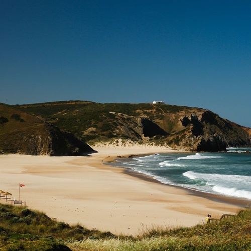una playa con un faro al fondo