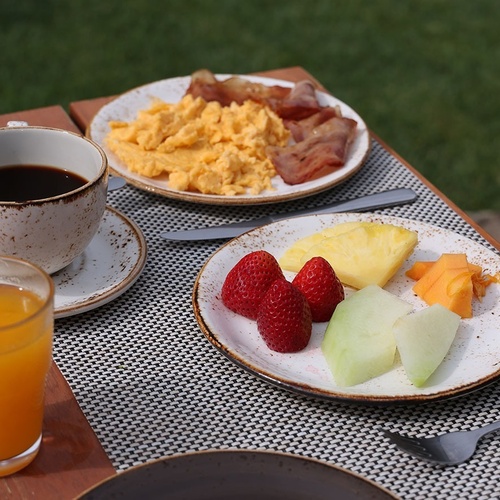 plates of food on a table with a cup of coffee and a glass of orange juice