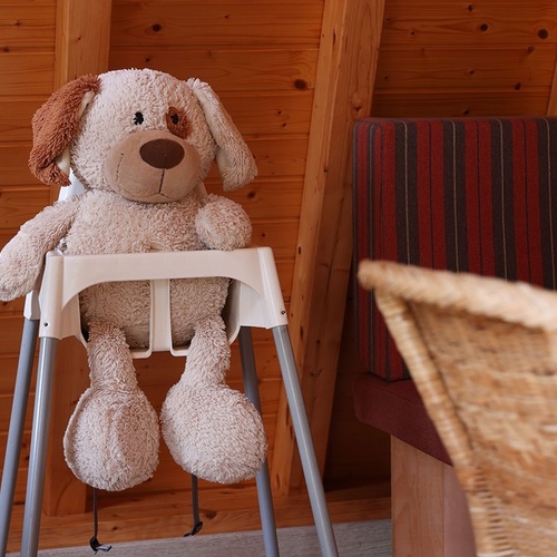 a stuffed dog is sitting in a high chair