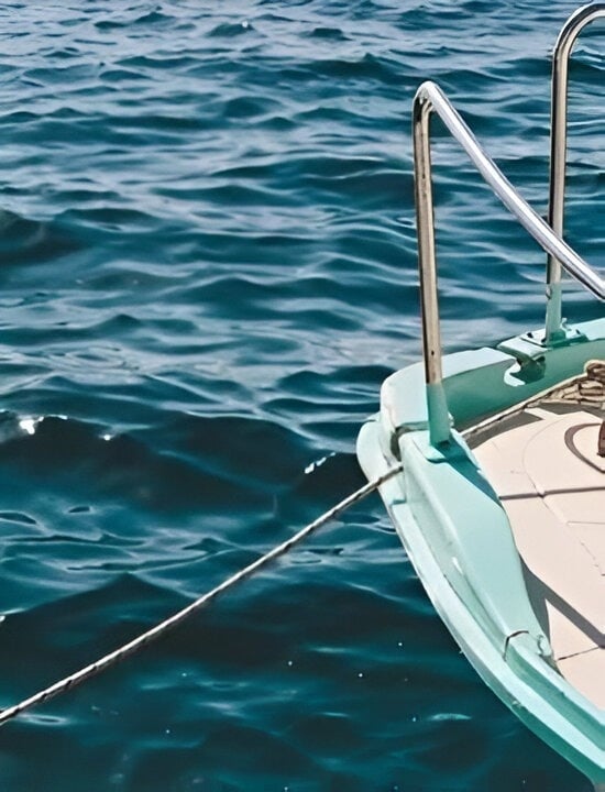 a boat is tied to a rope in the ocean .