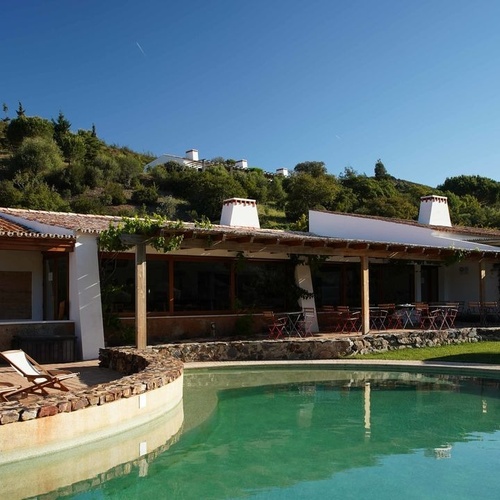 una gran casa blanca con una piscina al frente