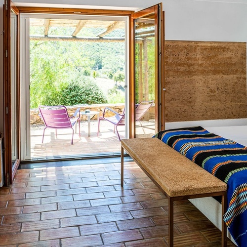 una habitación con una cama y una puerta que da a una terraza