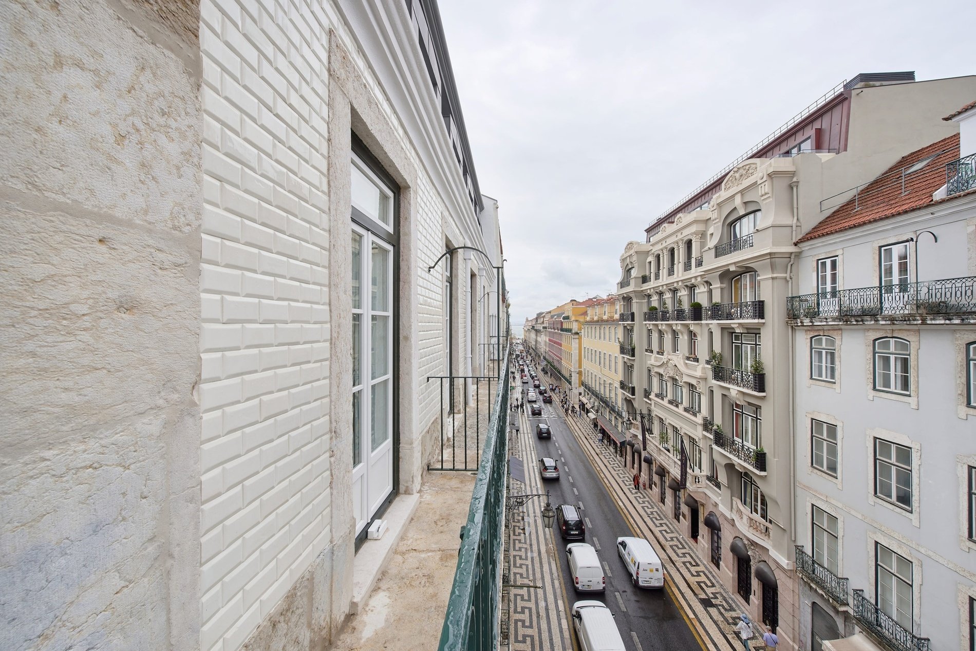 un edificio blanco con un letrero verde que dice " alquiler "