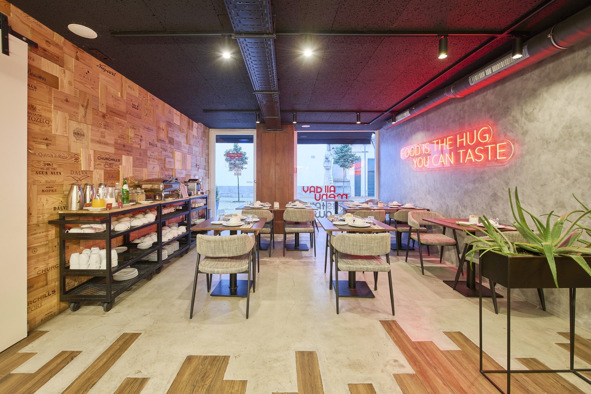 a restaurant with tables and chairs and a neon sign that says " giving the hug you can taste "