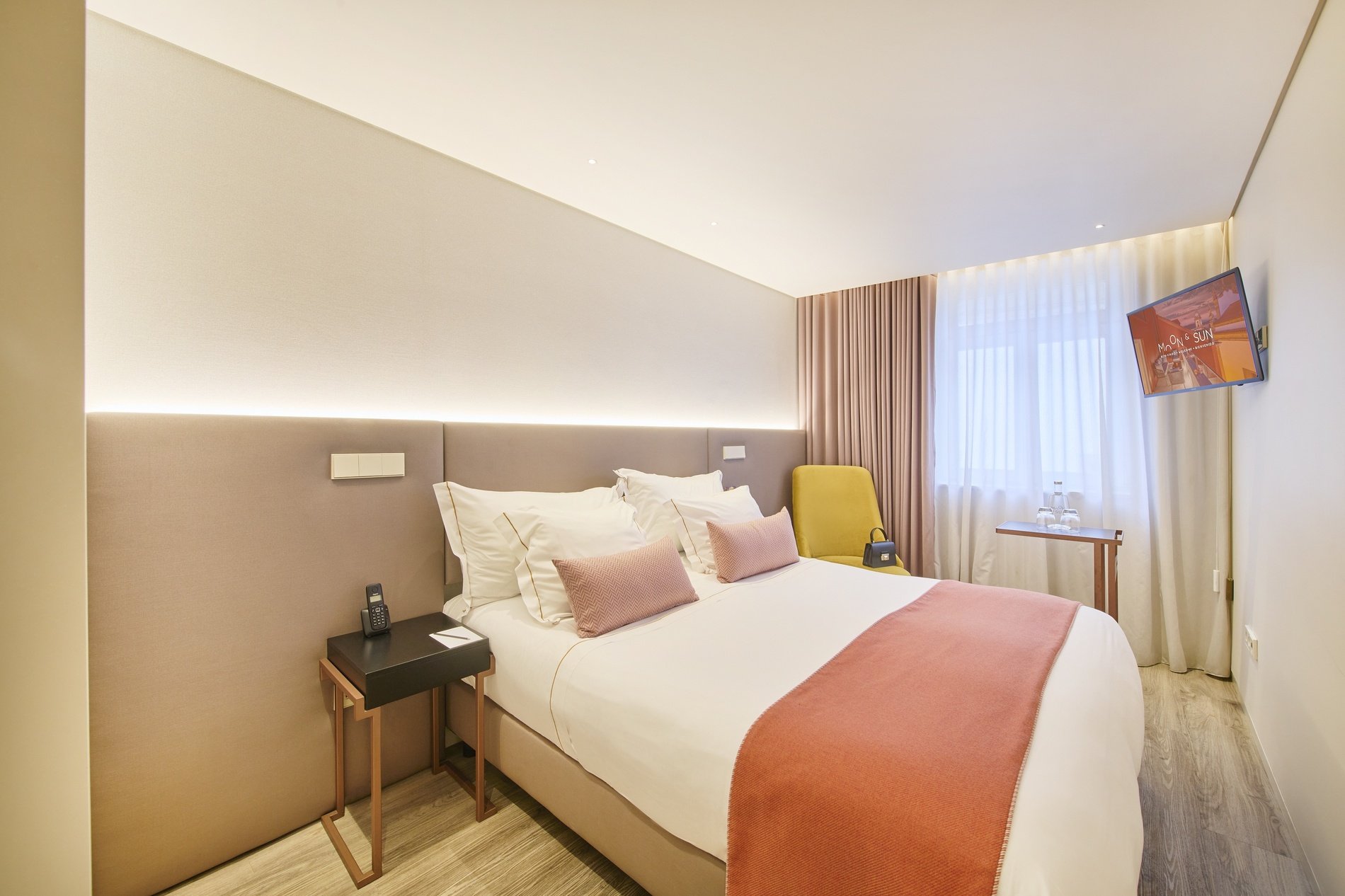 a hotel room with a large bed and a yellow chair