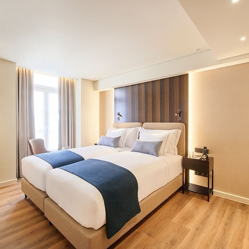 una habitación de hotel con dos camas y una maleta