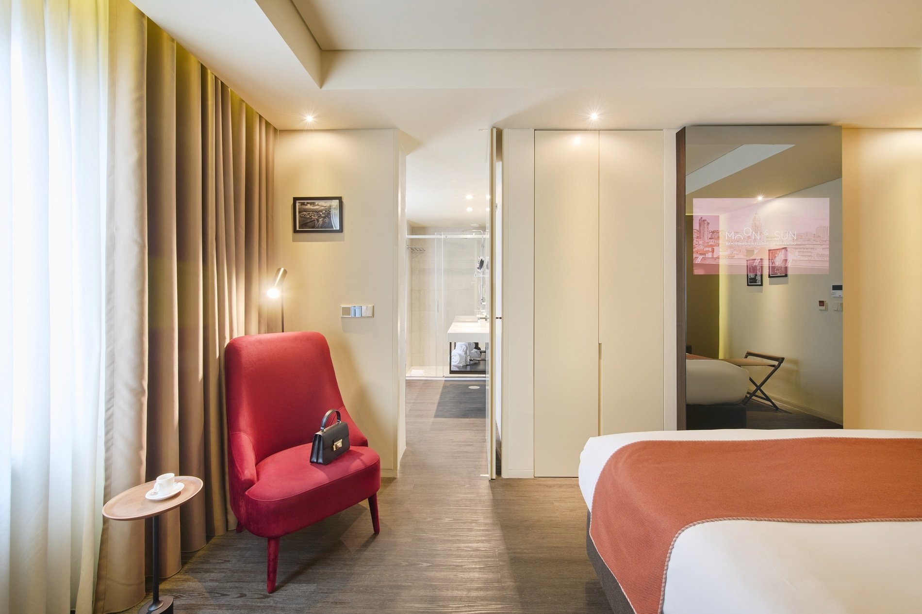 a hotel room with a bed and a red chair