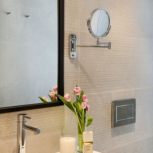 a bathroom sink with a candle and a bottle of chanel