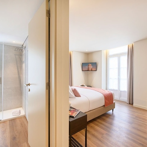 a hotel room with a bed and a television on the wall