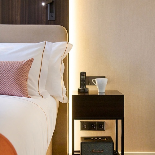 a marshall speaker sits on a nightstand next to a bed