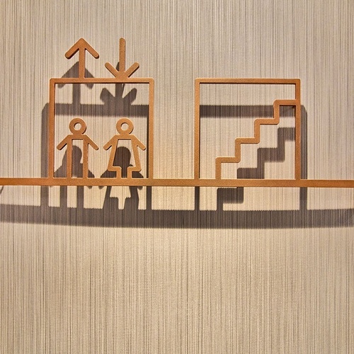 un cartel de madera que muestra la dirección del ascensor