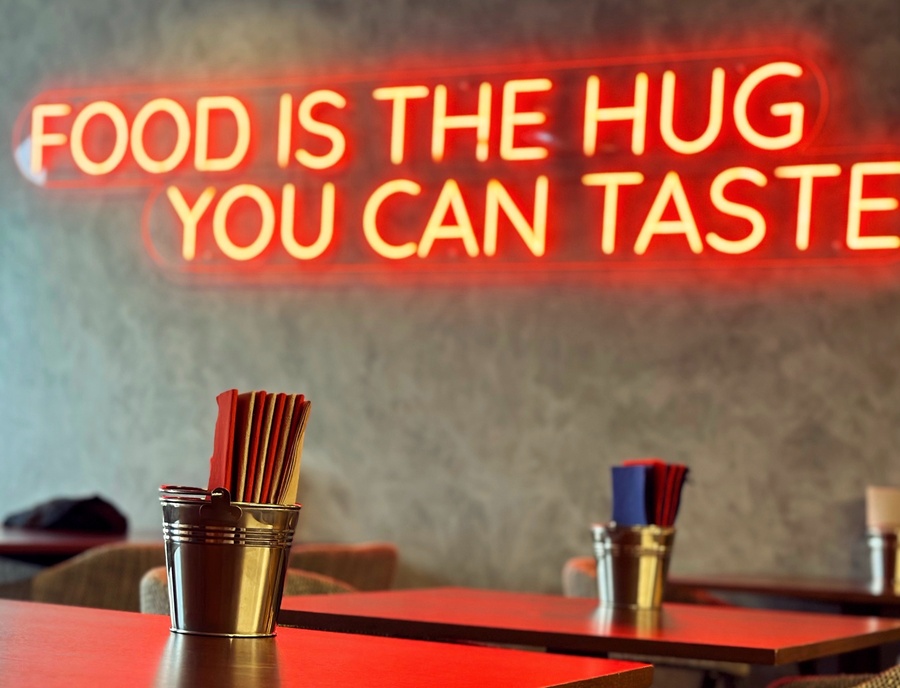 a neon sign that says food is the hug you can taste