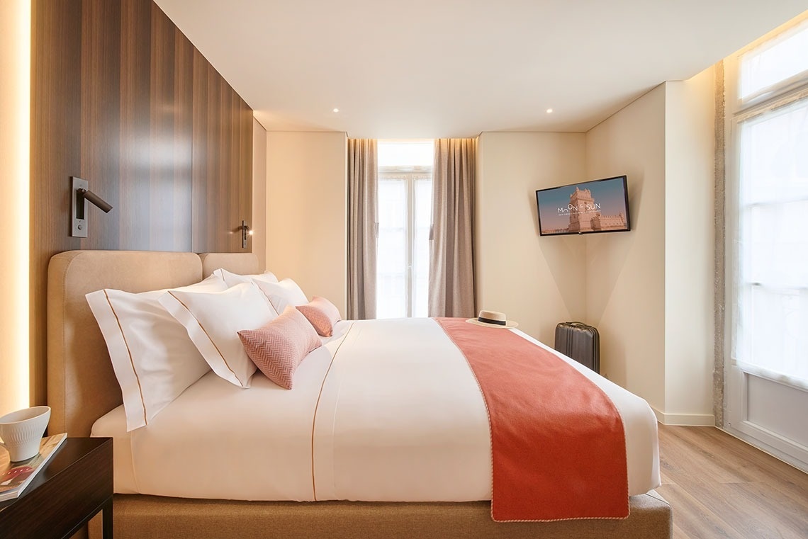 una habitación de hotel con una cama y una televisión que muestra la estatua de la libertad