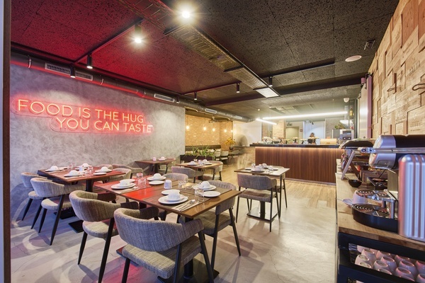 un restaurante con una señal de neón que dice " la comida es el abrazo que puedes saborear "