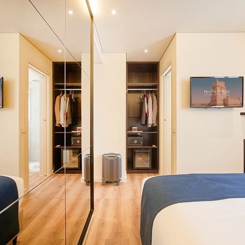 una habitación de hotel con dos camas y dos televisores