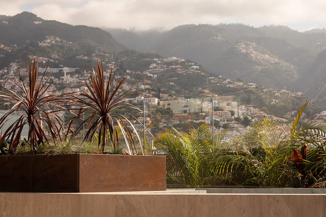Tropical plants and scenic mountain town view from a Moon & Sun: Corpo terrace.
