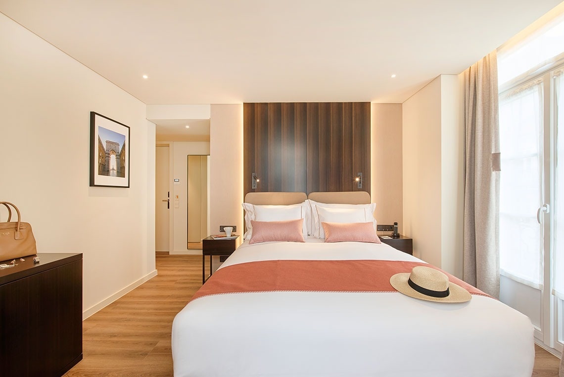 um quarto de hotel com uma cama e um chapéu