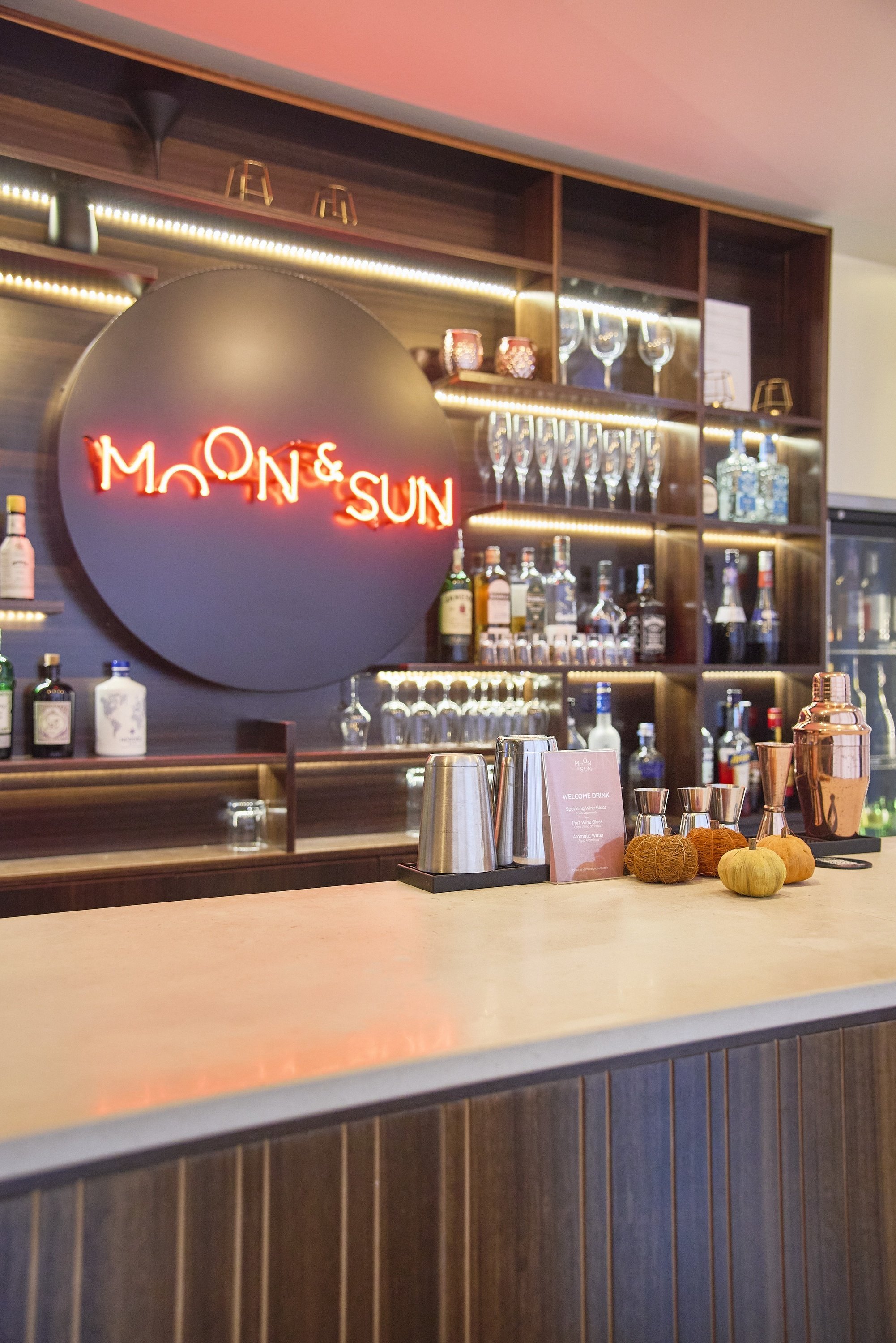 un bar con un letrero de neón que dice moon & sun