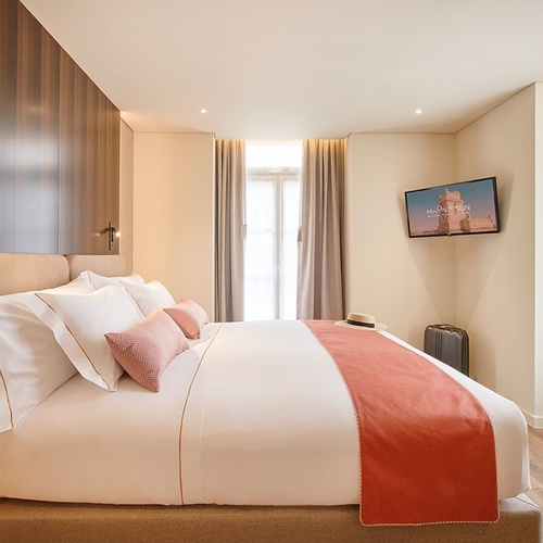 um quarto de hotel com uma cama e uma televisão