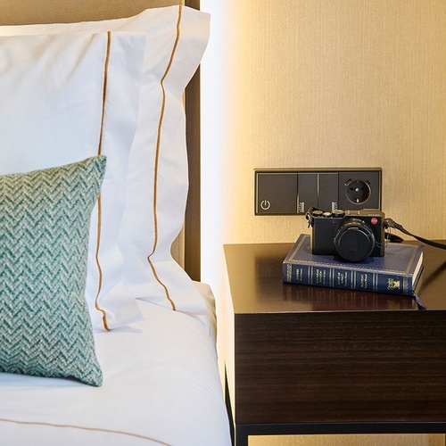 a leica camera sits on a nightstand next to a book