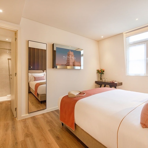 a hotel room with a bed and a picture of the tower bridge on the wall