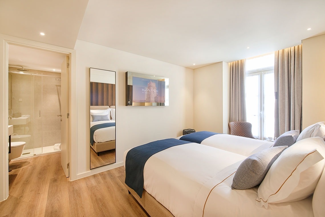a hotel room with two beds and a tv that says novotel